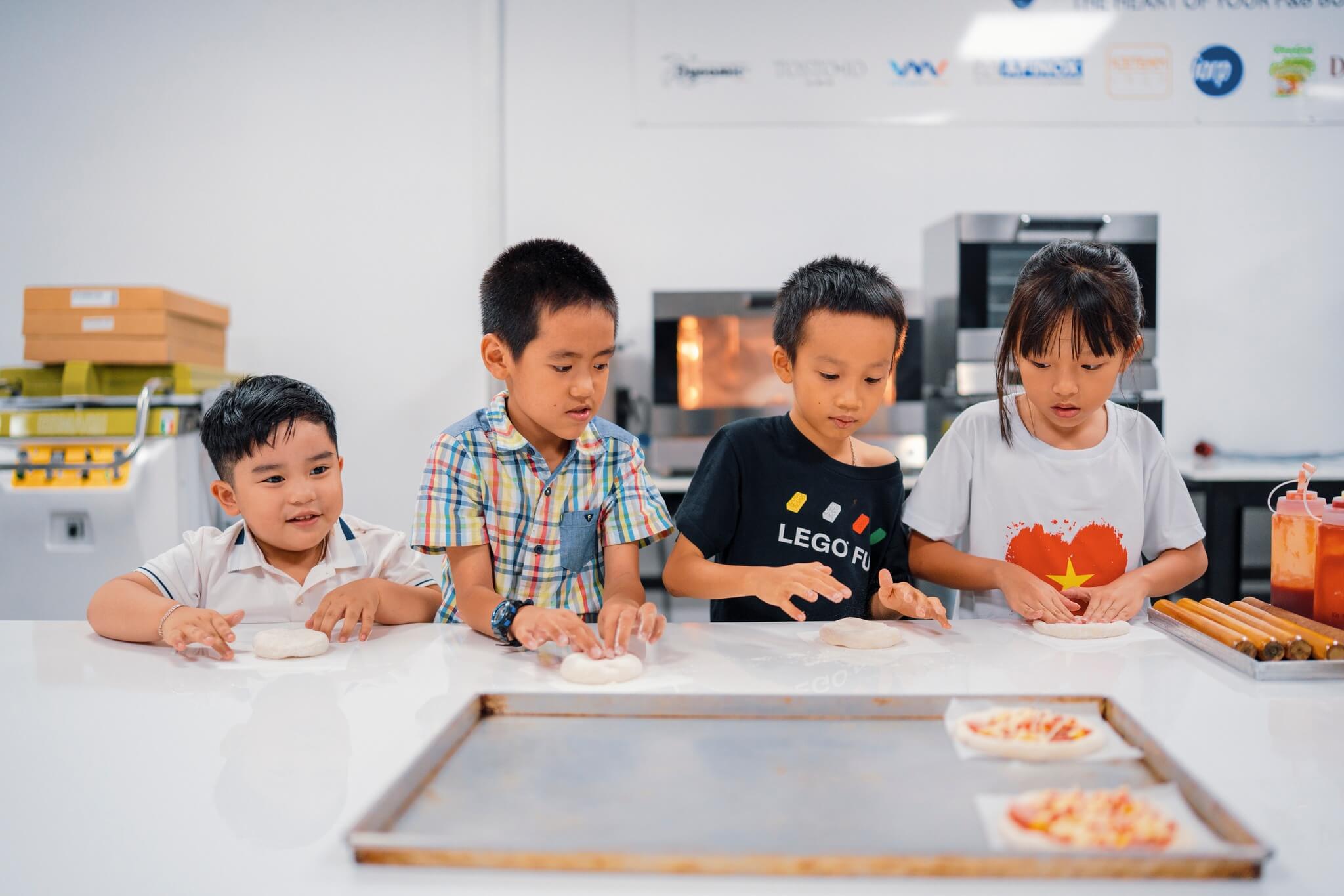 Ảnh các bé đang làm bánh pizza.