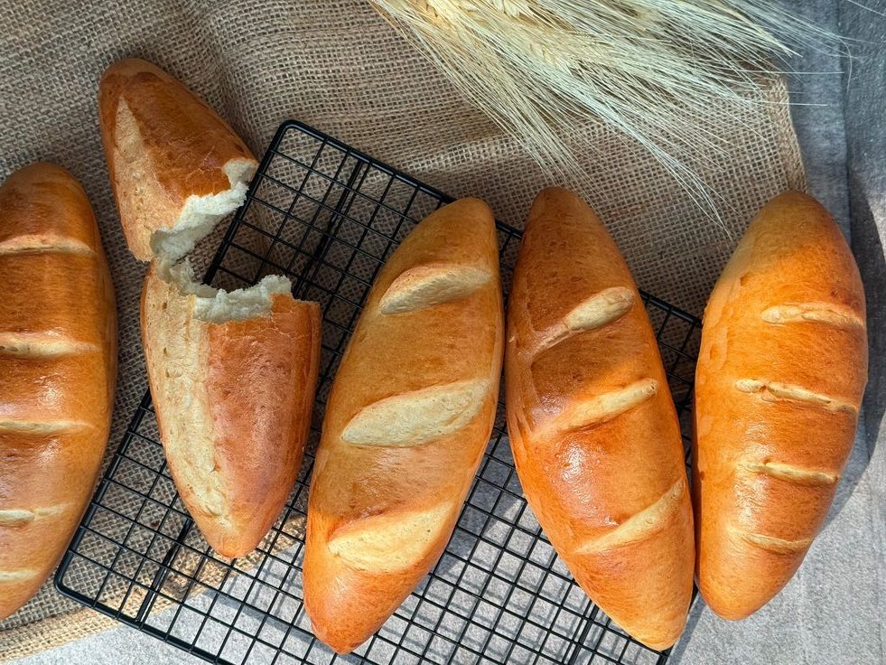 Ổ bánh mì giòn vàng trên rack nướng – bí quyết bảo quản bánh mì giòn lâu như mới.