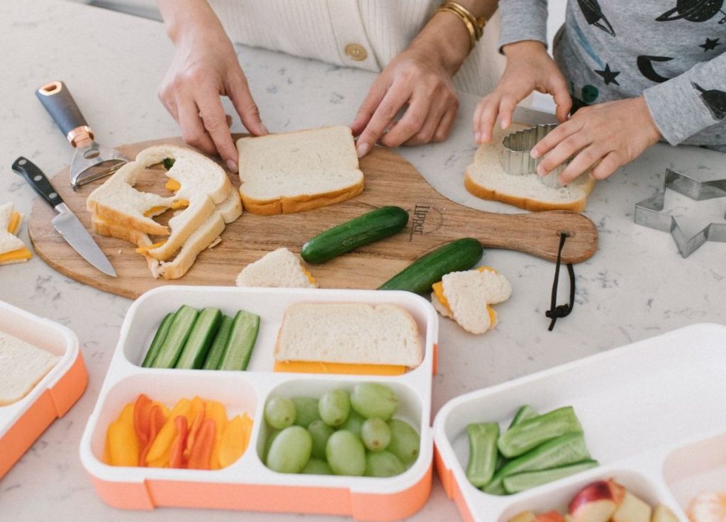 Khay nguyên liệu ẩm thực gồm bánh mì, rau củ và trái cây được chuẩn bị để trẻ bắt đầu khám phá ẩm thực qua những bước đơn giản.