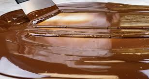 Chocolate thủ công đang được temper để đạt độ bóng, kết cấu mịn và hương vị đồng đều trong quy trình chế biến chocolate chuyên nghiệp.